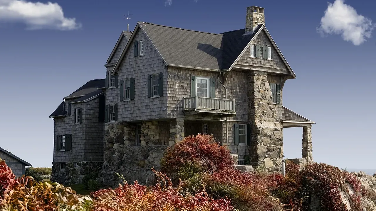 Two-storey stone and shingle house with a steep pitched roof